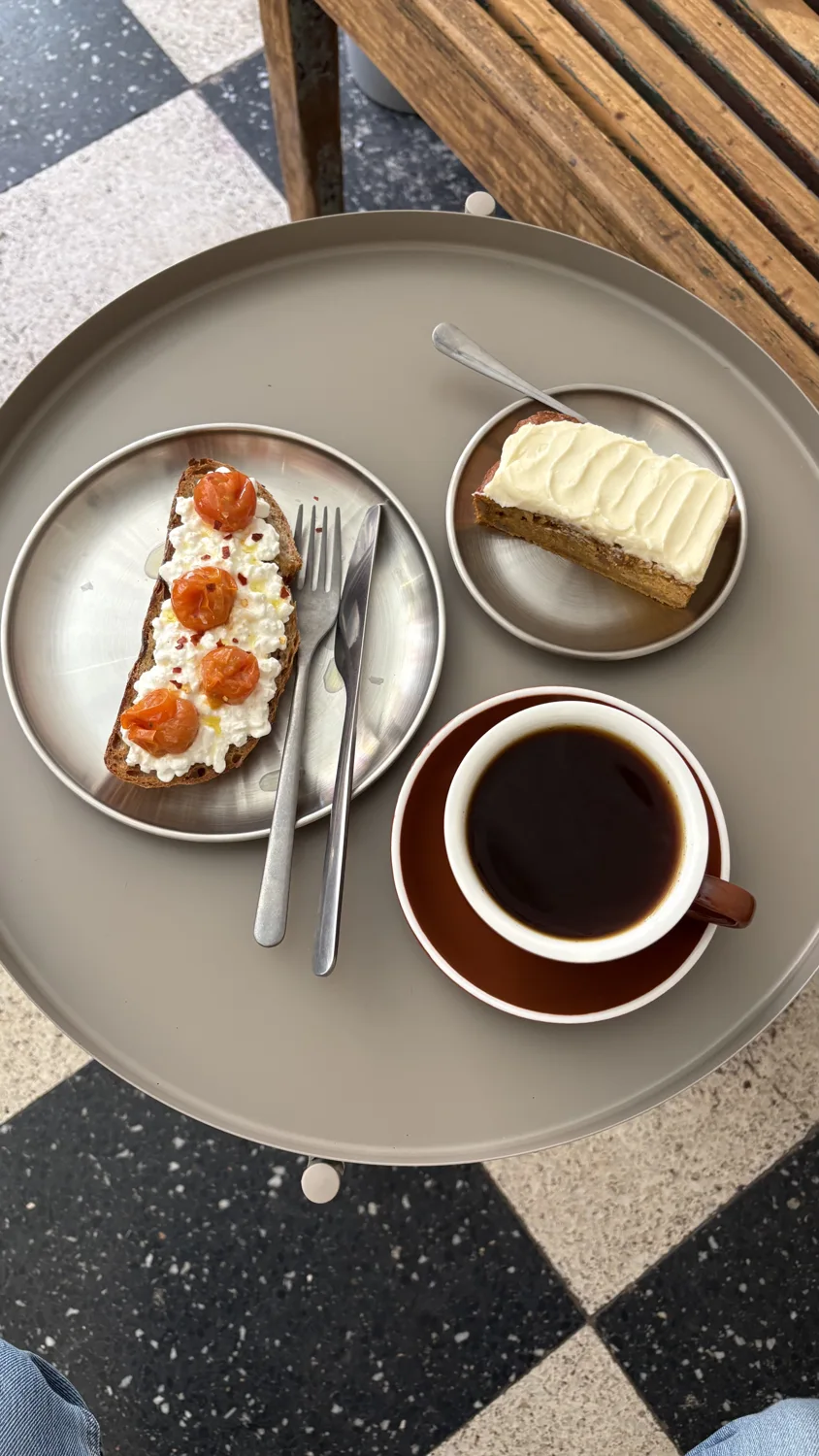 Café, tosta de queso cottage y bizcocho sobre una mesa
