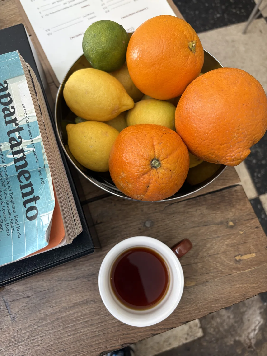 Café, fruta y una revista en una mesa de DOPA